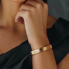 This custom handwritten bracelet is a beautiful combination of personalization and elegance. Crafted from 14k gold, this open cuff bracelet features a delicate 7mm width, making it perfect for everyday wear. Designed as a unisex bracelet, it suits both men and women, and its adjustable feature ensures a comfortable fit for any wrist size. The bracelet's unique custom handwritten message adds a personal touch, making it an ideal gift for her. Whether it's a name, date, or special message, this bracelet allows you to carry a cherished memory with you. Handmade with precision, this gold bracelet exemplifies fine craftsmanship and thoughtful design, making it a standout piece in any jewelry collection. 📏 Wrist Size: Kindly provide your wrist size in the designated text box or the drop-down me Elegant Engraved Name Bracelet For Bridesmaid, Elegant Bangle Name Bracelet For Bridesmaid Gift, Elegant Gold Name Bracelet With Custom Text, Elegant Gold Cuff Bracelet With Custom Name, Elegant Hand Stamped Name Bracelet For Mother's Day, Elegant Name Cuff Bracelet As Gift, Elegant Customizable Bracelets For Promise, Elegant Engraved Cuff Bracelet For Personalized Gift, Elegant Engraved Cuff Bracelet As Personalized Gift