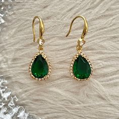 Welcome to our collection of emerald teardrop gold earrings, a must-have for anyone looking to add a touch of luxury and sophistication to their wardrobe. Handcrafted with meticulous attention to detail, these earrings feature stunning teardrop-shaped emerald gemstones suspended from delicate and durable gold settings. Our emerald teardrop gold earrings are the perfect accessory for any occasion, whether you're dressing up for a formal event/wedding or adding a touch of elegance to your everyday Classic Emerald Pear-shaped Earrings, Pear-shaped Bridal Earrings For Evening, Classic Pear-shaped Emerald Earrings, Formal Pear-shaped Emerald Earrings, Green Pear-shaped Earrings For Formal Events, Formal Teardrop Emerald Jewelry, Elegant Teardrop Pendant Earrings For Pierced Ears, Elegant Teardrop Pendant Earrings, Elegant Teardrop Crown Earrings As Gift