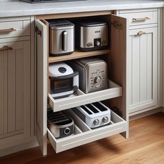 an open cabinet in a kitchen with toasters and other appliances