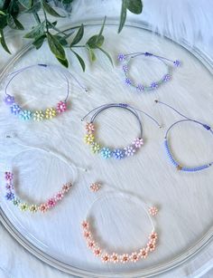 four bracelets on a plate with flowers in the background