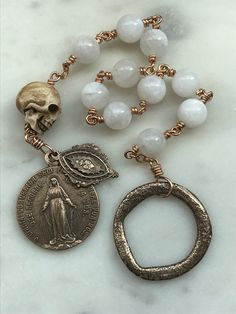 Wonderful wire-wrapped Penal Rosary. Bronze Reproductions of antique medals 20 gauge bronze wire, 8mm moonstone gemstones Ox bone skull Spiritual Brass Jewelry For Commemoration, Spiritual Jewelry With Antique Finish, Antique Brass Wire Wrapped Jewelry, Spiritual Moonstone Jewelry For Collectors, Antique Wire Wrapped Brass Jewelry, Spiritual Soldered Moonstone Jewelry, Vintage Rosary Antiques, Silver Rosary With Natural Stones, Handmade Bronze Spiritual Rosary