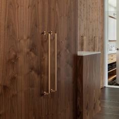 a bathroom with wood paneling and brass handles