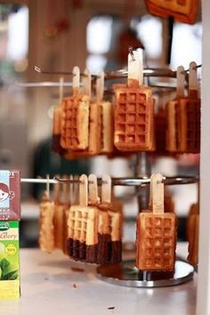 some waffles are hanging from a rack with toothpicks attached to them