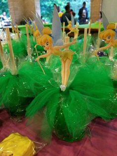 there are many tinkerbells on the table with green tulle skirtes