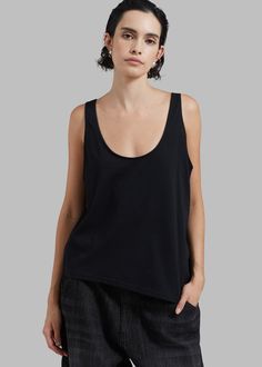 Color: Black Lightweight cotton fabric Reversible style Relaxed fit Round neckline Asymmetrical hem Sleeveless Unlined 100% Cotton Machine Wash Cold By The Frankie Shop. Imported Cotton Tops With Wide Straps For Everyday, Chic Cotton Scoop Neck Tank Top, Versatile Cotton Tank Top With Scoop Neck, Versatile Cotton Scoop Neck Tank Top, Black Cotton Tank Top For Layering, Chic Black Cotton Tank Top, Denim Suit, The Frankie Shop, Frankie Shop