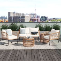 an outdoor seating area with wicker furniture and cityscape in the back ground