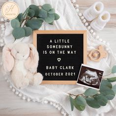 a little bunny is on the way sign next to a teddy bear and baby's photo