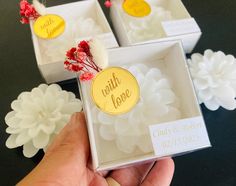 three small boxes with wedding favors in them