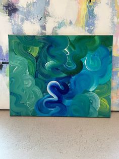 an abstract painting with blue, green and white swirls on the bottom half of it