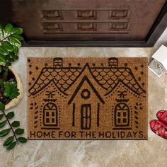 a door mat that says home for the holidays on it next to shoes and plants