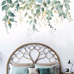 a bed sitting under a green leafy wall mural