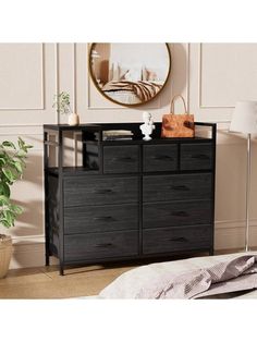 a black dresser with drawers next to a mirror