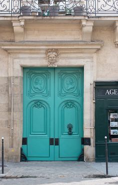 an aqua green door on the side of a building