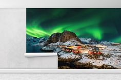 an image of the northern lights over a snowy mountain range with houses and mountains in the foreground