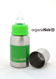 a green and silver water bottle sitting next to a black cup on a white surface