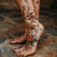 a woman's legs with tattoos and flowers on them