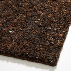 a close up view of a brown rug on a white surface with dirt all over it