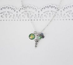 Are you a fan of Loki? This charm necklace features all the icons of this mischievous Asgardian! Featuring custom art of Loki's helm, a silver dagger and sparkling color coordinating beads.----------☆----------24 inch Sterling Silver plated chainsGlass cabochon Loki artCharms are silver plated, lead and nickel freeLoki's daggerGlass beadsUSA HANDMADE SELLER!Why are handmade cabochons important? I believe in a truly handmade product. I don't import in pre-made cabochons. I first design the graphi Charmed Comics, Loki Helmet, Adoptable Oc, Marvel Gifts, Bff Necklaces, Friendship Jewelry, Handmade Sellers, Charm Necklace Silver, Loki Laufeyson