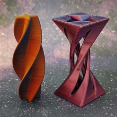 two colorful vases sitting next to each other on a table