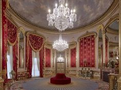 an elaborately decorated room with red curtains and chandelier