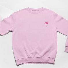 Flamingo Embroidered Sweatshirt. Soft Cotton drop shoulder style with stylish fit. Designed and Embroidered in the UK. Unisex Fit. Vegan.   JUMPER INFO Flamingo embroidered by twin needle stitching. We use sustainable fabric and the jumper is fair trade certified. Sweatshop free and WRAP certified. Shipped in recyclable and biodegradable packaging. Plastic free. Casual Cotton Flamingo Print Tops, Casual Cotton Tops With Flamingo Print, Long Sleeve Embroidered Pink T-shirt, Pink Embroidered Long Sleeve T-shirt, Pink Long Sleeve Embroidered T-shirt, Pink Embroidered Sweatshirt With Relaxed Fit, Pink Embroidered Relaxed Fit Sweatshirt, Pink Embroidered Crew Neck Top, Embroidered Flamingo