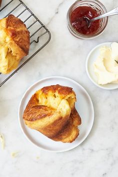 two plates with pastries sitting on a table next to some sauces and condiments