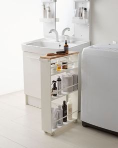 a white sink sitting under a bathroom mirror next to a counter with bottles and soaps on it