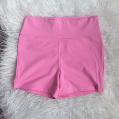 a pink shorts is laying on a fluffy white carpet