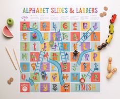 the alphabet slides and ladders game is laid out on a table