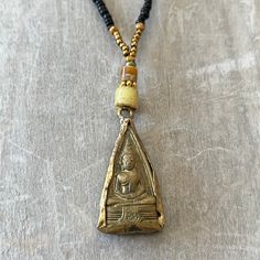 This one-of-a-kind vintage brass Buddha pendant has a unique beaded necklace. M Hand strung on 7 strand wire with a lobster clasp. This necklace hangs 11 inches from clasp to bottom of pendant. Handmade Vintage Pendant Beaded Necklaces, Handmade Vintage Pendant Beaded Necklace, Vintage Brass Beaded Necklace With Round Beads, Vintage Bronze Beaded Necklaces With Round Beads, Adjustable Brass Necklace With Gold Beads, Adjustable Brass Necklaces With Gold Beads, Handmade Vintage Beaded Necklaces For Meditation, Gold Beaded Necklace With Large Pendant, Unique Gold Beaded Necklace With Large Pendant