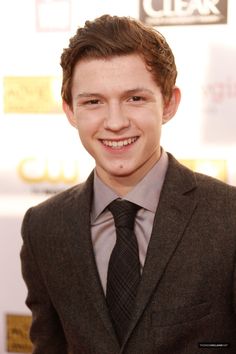 a young man in a suit and tie smiles for the camera at an awards ceremony