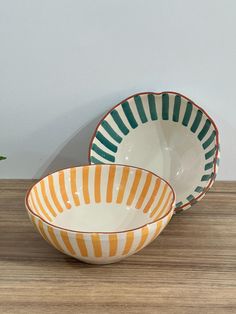 two bowls sitting on top of a wooden table