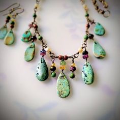 Necklace & Earrings set.  Loving the blue-greenhue of these Mexican turquoise raindrops, dangling with accents of tourmaline, mother of pearl, goldstone and African turquoise.  Suspended from my hand twisted, *Non-tarnish* bronze links.  Necklace is 17.5 inches long, and earrings dangle just shy of 1.5 inches below the earlobe. *The bronze chain is of excellent quality and has been treated to never tarnish and always remain the original color. Green Artisan Dangle Jewelry, Artisan Green Dangle Jewelry, Artisan Teardrop Gemstone Beads Jewelry, Nature-inspired Jewelry With Dangling Beads For Gifts, Green Teardrop Bohemian Jewelry, Bohemian Green Teardrop Jewelry, Unique Teardrop Jewelry With Dangling Beads, Nature-inspired Multicolor Dangle Jewelry, Artisan Jewelry With Green Dangling Beads