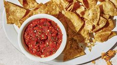 a white plate topped with chips and salsa