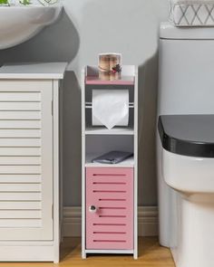 a white toilet sitting next to a pink cabinet