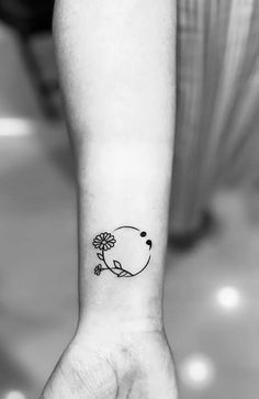 a small flower tattoo on the wrist