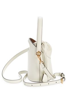 A dipped topline and oval cutout showcase the encased drawstring pouch of this structured leather bucket bag furnished with a top handle and removable strap. Drawstring closure Top carry handle; removable, adjustable crossbody strap Striped-twill lining Structured silhouette with flat base and protective metal feet Leather Imported Designer Handbags Designer Cream Bucket Bag, Designer Cream Bucket Bag With Detachable Handle, Cream Bucket Bag With Handle Drop, Luxury Cream Bucket Bag With Detachable Handle, Formal Cream Bucket Bag With Adjustable Strap, Formal White Bucket Bag With Handles, Formal White Bucket Bag, Leather Bucket Bag, Leather Bucket