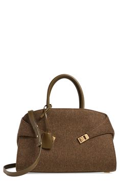 a brown handbag on a white background with a gold lock in the middle and two handles