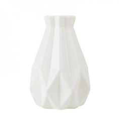 a white vase sitting on top of a table