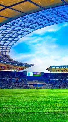 a soccer field with the sky in the background and grass on the ground below it