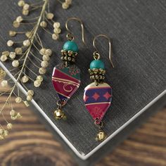 Looking for unique boho style jewelry? Don't miss out on these one-of-a-kind bohemian earrings! Carefully handcrafted from recycled vintage tins, these elegant earrings feature colorful patterns, adding a special touch. Lightweight and stylish, they are finished with glass beads and hypoallergenic antiqued brass ear wires. I take great care in crafting my vintage tin earrings, ensuring smooth edges through a meticulous sanding process. Given the vintage materials used, minor imperfections may be present, adding to their charm and uniqueness. These bohemian earrings measure about 2" long from the top of the wire to the bottom and are about 1/2" wide. Feel free to reach out if you have any questions at all. Thank you for visiting my shop, and be sure to check back often as I'm always creatin Vintage Multicolor Brass Earrings, Bohemian Drop Earrings For Vintage Collection, Red Bohemian Soldered Earrings, Bohemian Vintage Drop Earrings, Bohemian Red Soldered Earrings, Bohemian Multicolor Brass Earrings, Bohemian Patina Earrings, Bohemian Patina Earrings For Gift, Bohemian Festival Earrings With Patina