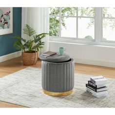 a living room with a round ottoman and books on the floor in front of it