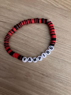 a red and black beaded bracelet with the word vampire written in white letters on it