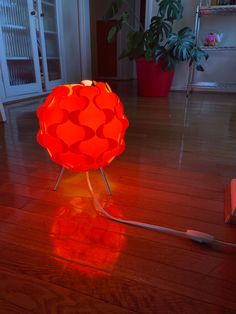 an orange lamp sitting on top of a hard wood floor