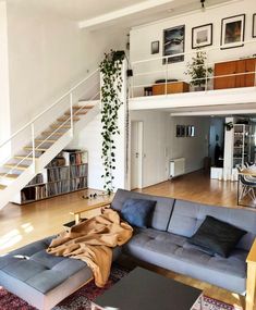 a living room filled with furniture next to a stair case