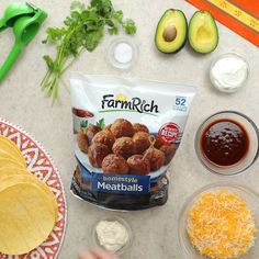 ingredients to make homemade meatballs laid out on a counter with tortilla chips and avocado