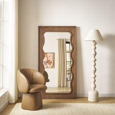 a living room with a chair, mirror and lamp on the floor in front of it