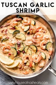 a pan filled with shrimp, zucchini and other vegetables on top of a table