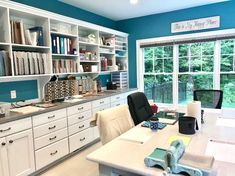 an office with blue walls, white cabinets and lots of books on the desks