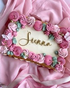 there is a cake decorated with pink flowers and the word june on it in gold lettering